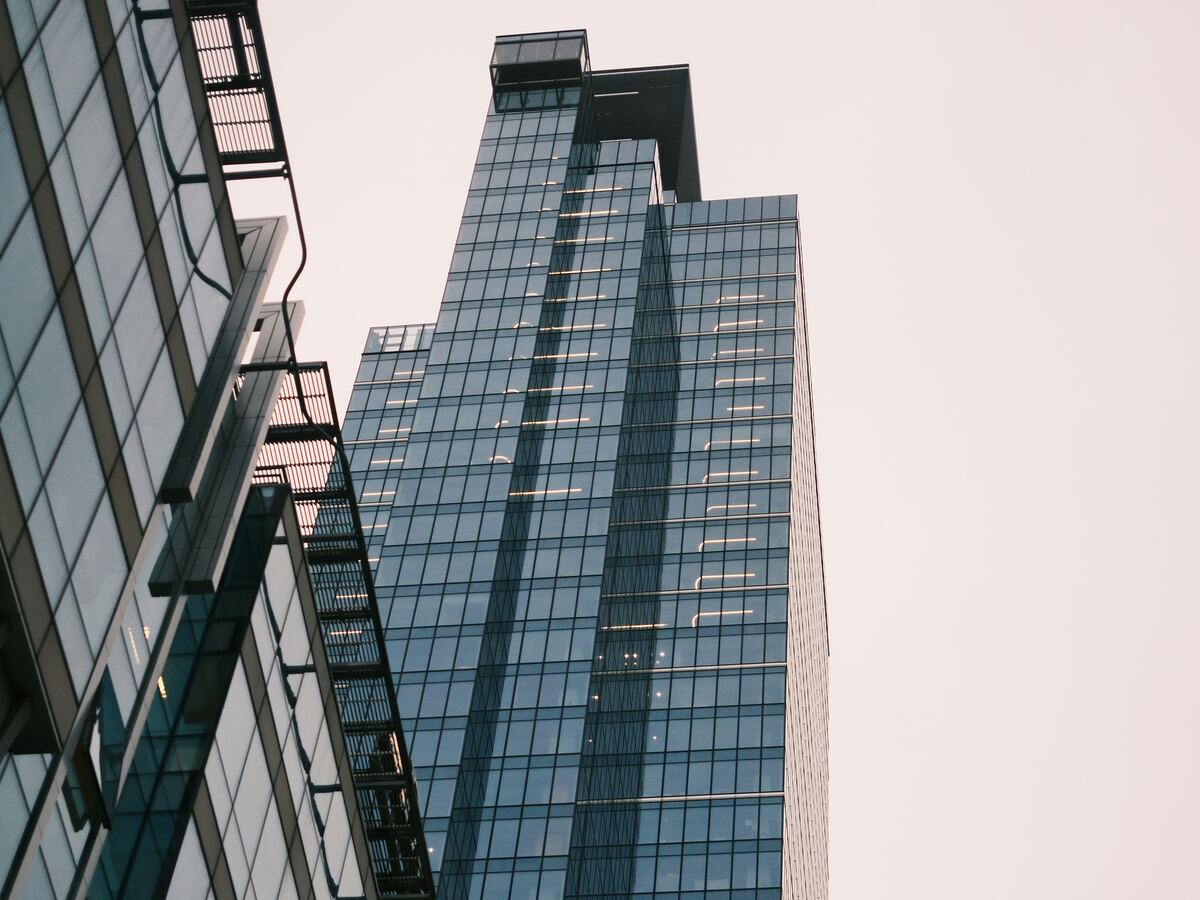Glass-clad commercial office tower viewed from street level