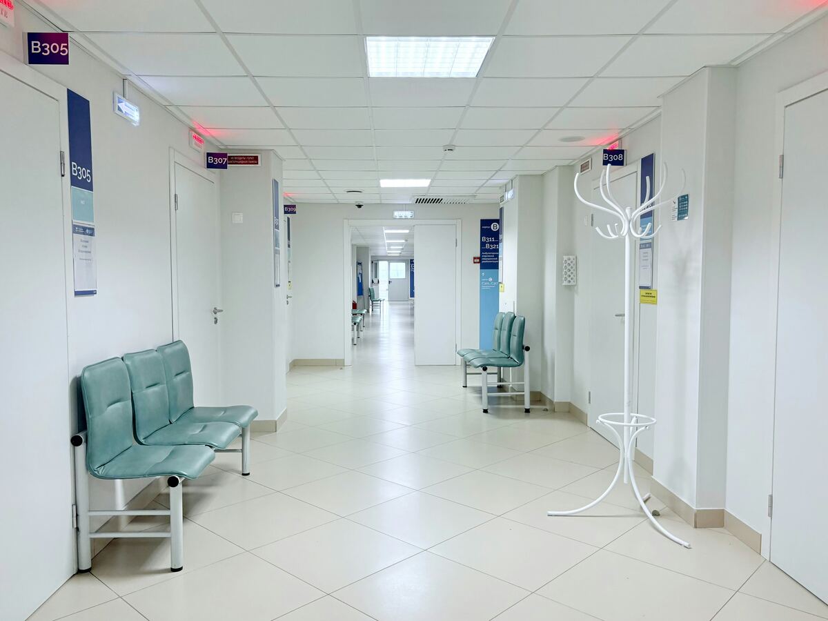 Clean, brightly lit healthcare facility corridor with waiting seating