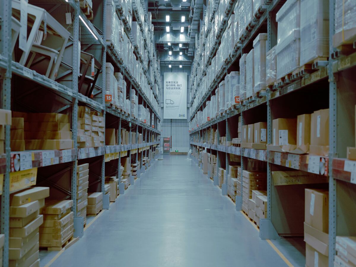 Warehouse aisle with high racking and stacked pallets