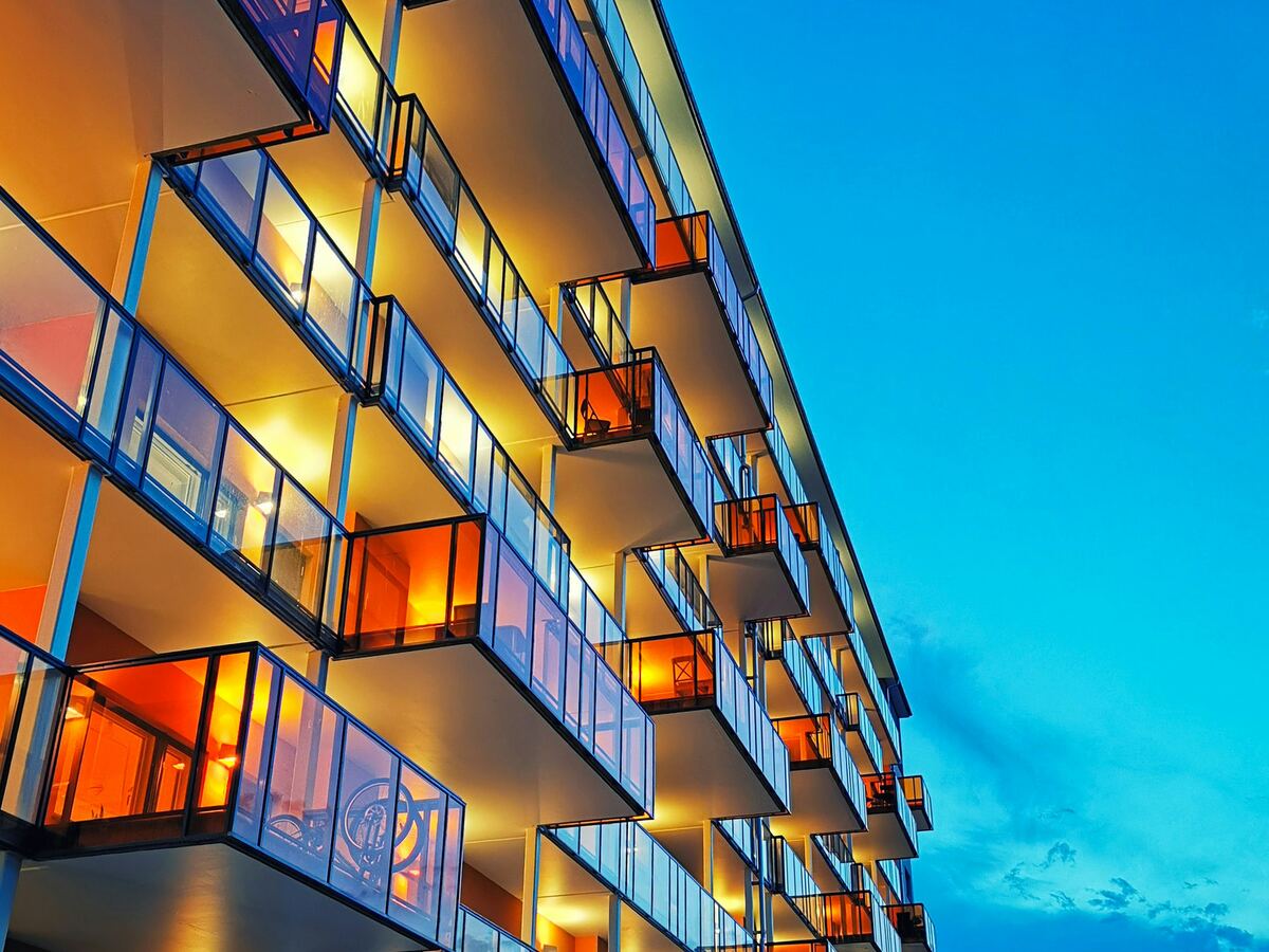 Modern apartment building with illuminated balconies at dusk